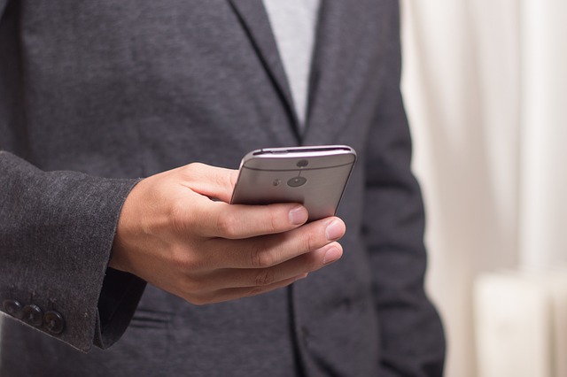 A man in suit operating a smartphone