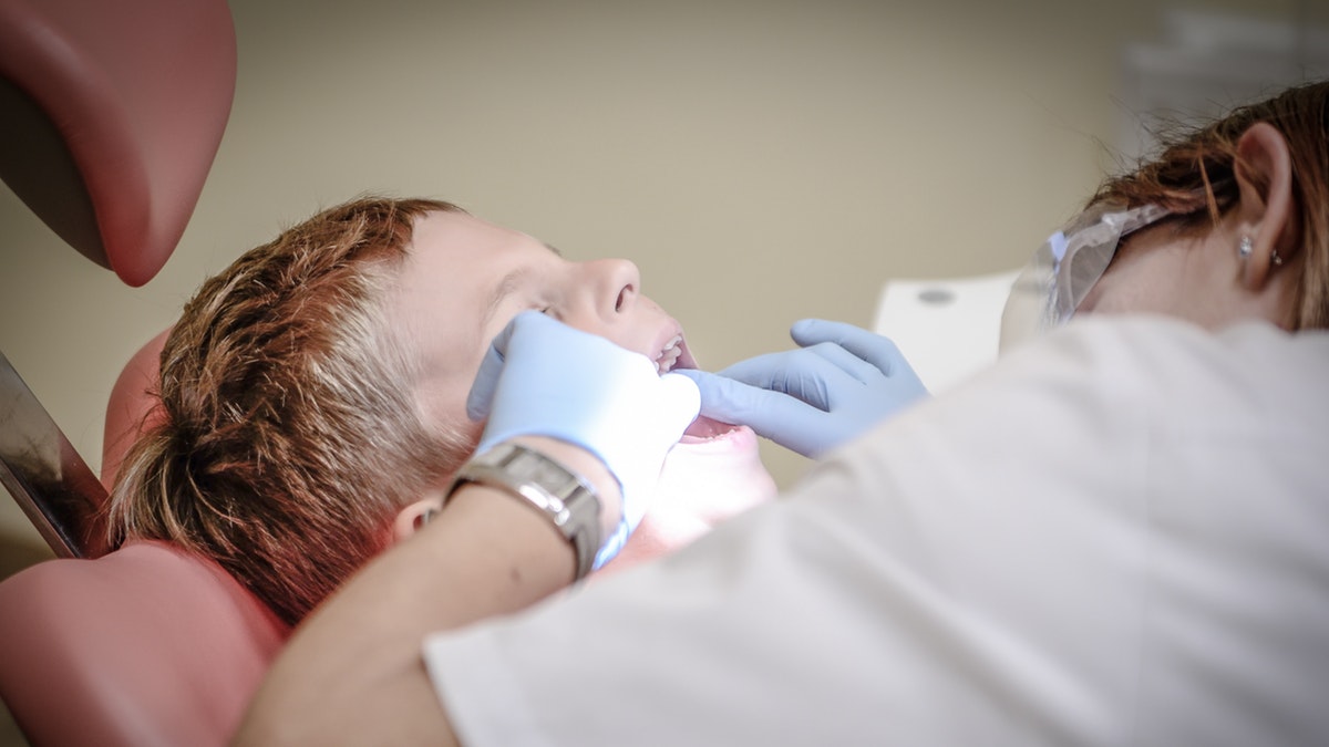 A dentist checking a patient's teeth